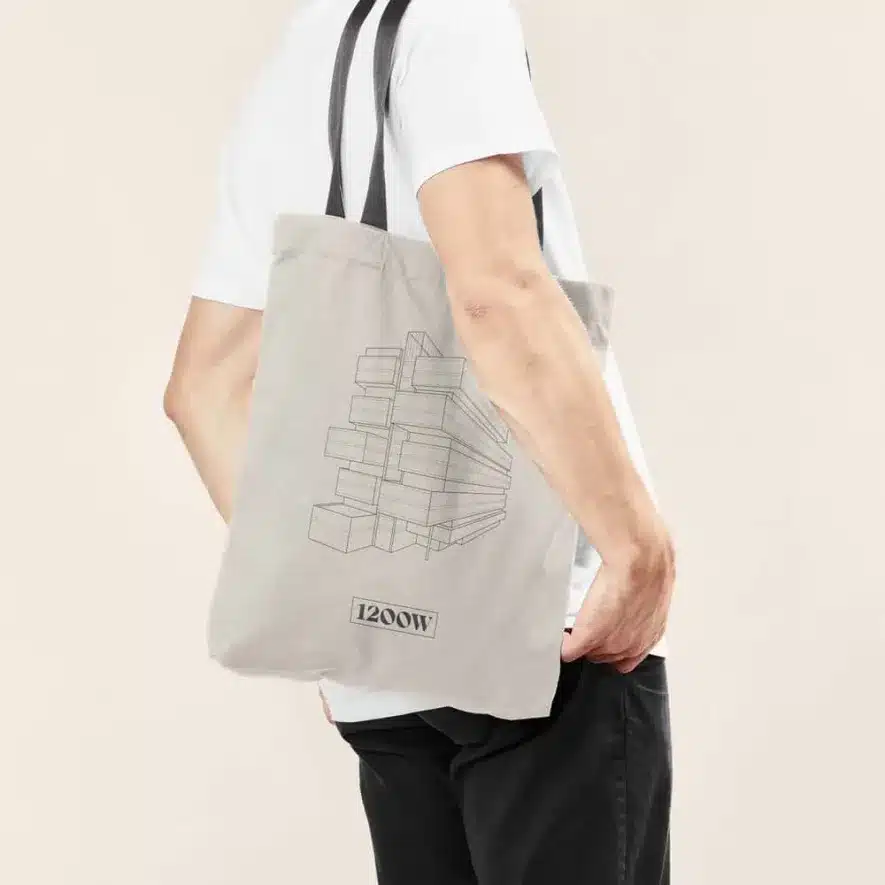 Gray fabric tote bag featuring a sketched geometric building and 1200W branding