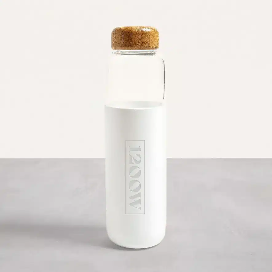 White glass water bottle with bamboo lid and subtle 1200W branding on the surface