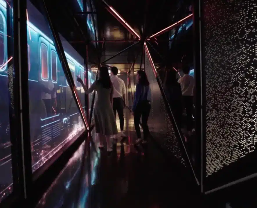Guests walking through a digital corridor with a futuristic subway projection on the walls