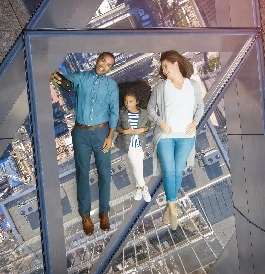 Visitors enjoying a unique perspective on Edge’s transparent floor, floating above New York