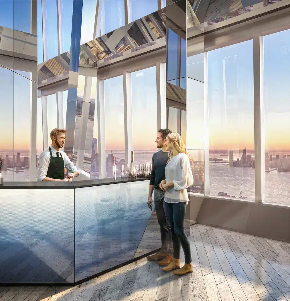 A couple chatting with a bartender at Edge’s sky-high bar, overlooking the city skyline