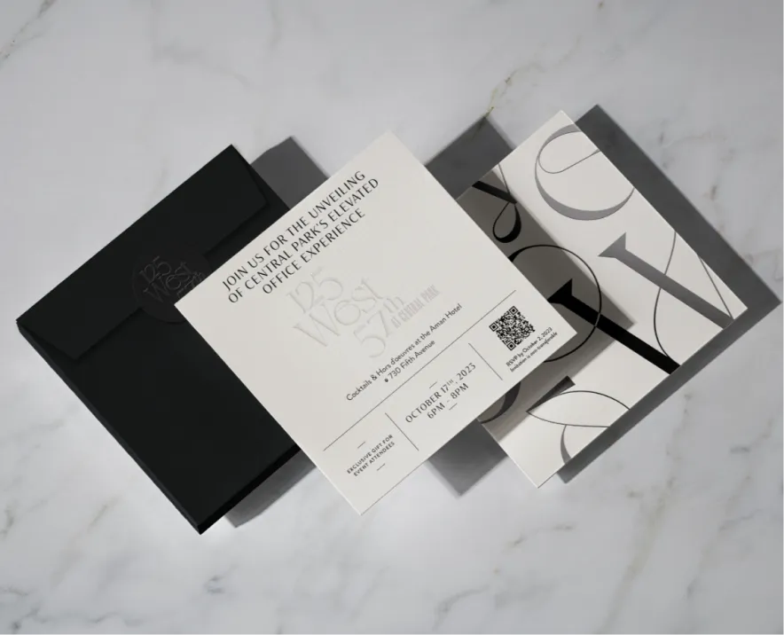 High-end event invitation with sleek typography, black envelope, and marble background