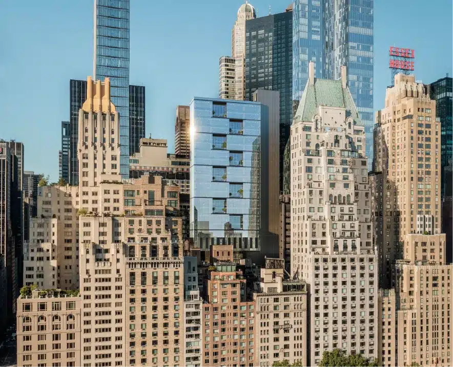 Modern glass high-rise blending into the Manhattan skyline with a reflective facade