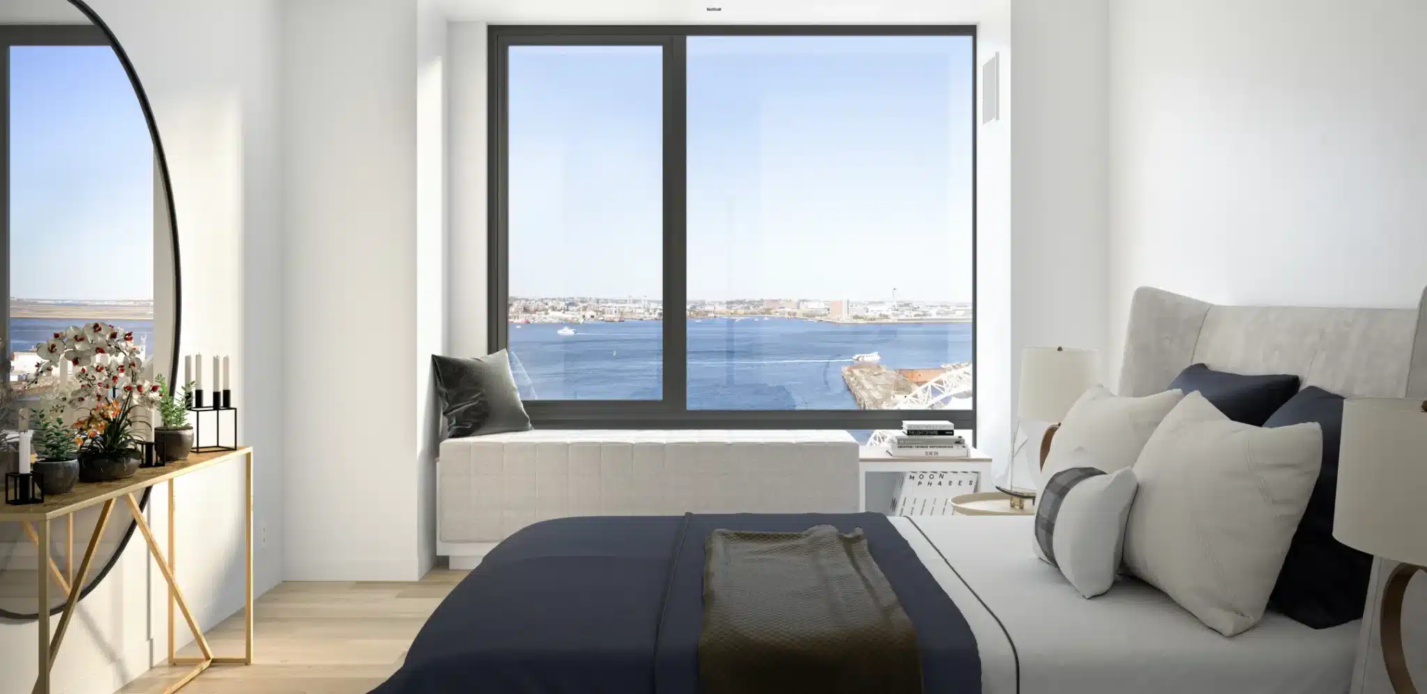 Modern bedroom with a large window overlooking a waterfront cityscape at Ora Seaport apartments