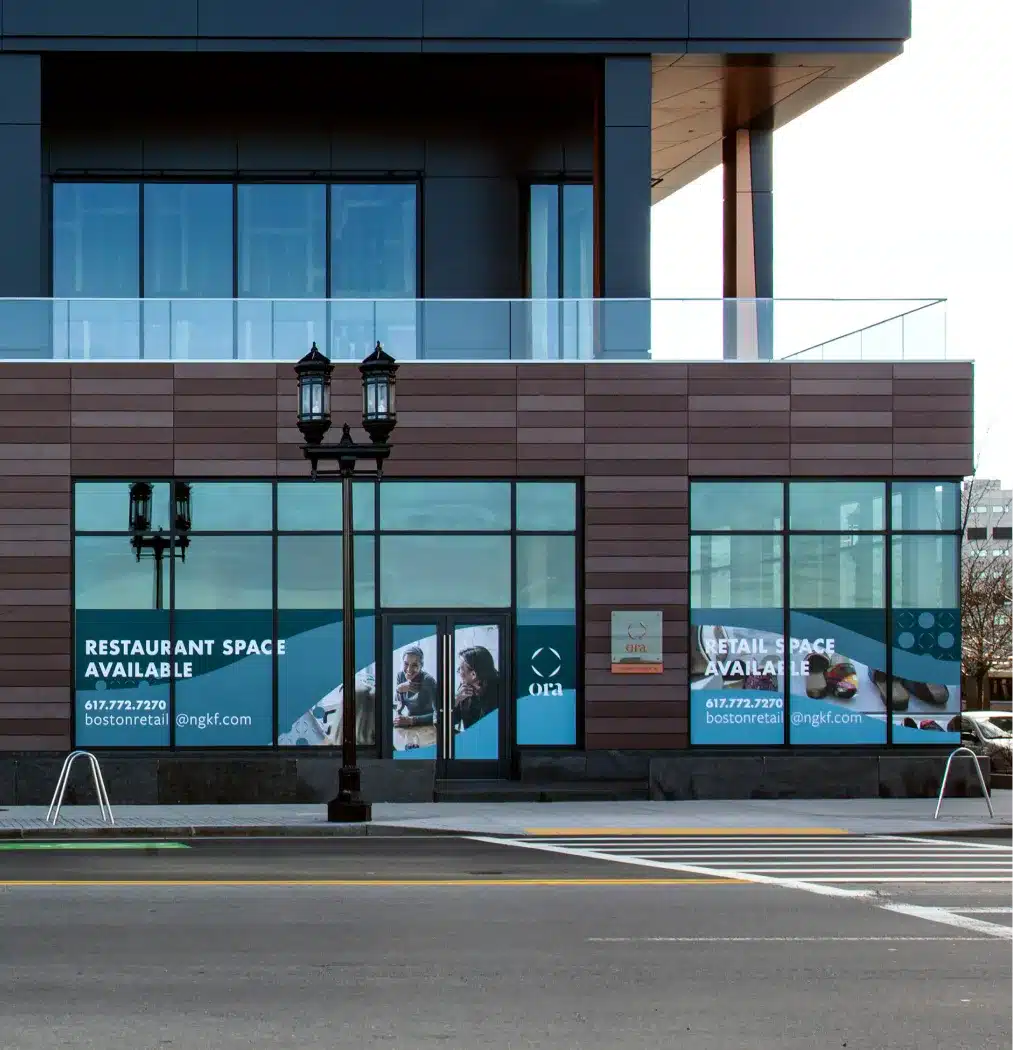 Exterior of Ora Seaport retail and restaurant space with large glass windows and promotional signage