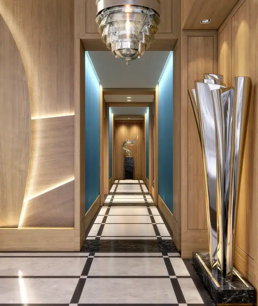Elegant hallway at St. Regis Residences, featuring warm wood finishes and artistic sculptures