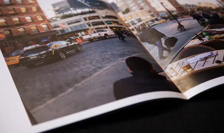 Close-up of a printed real estate brochure featuring cobblestone streets and urban lifestyle