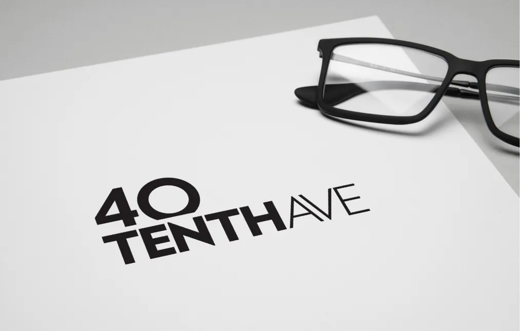 Close-up of 40 Tenth Avenue branding on white paper with black glasses on a desk
