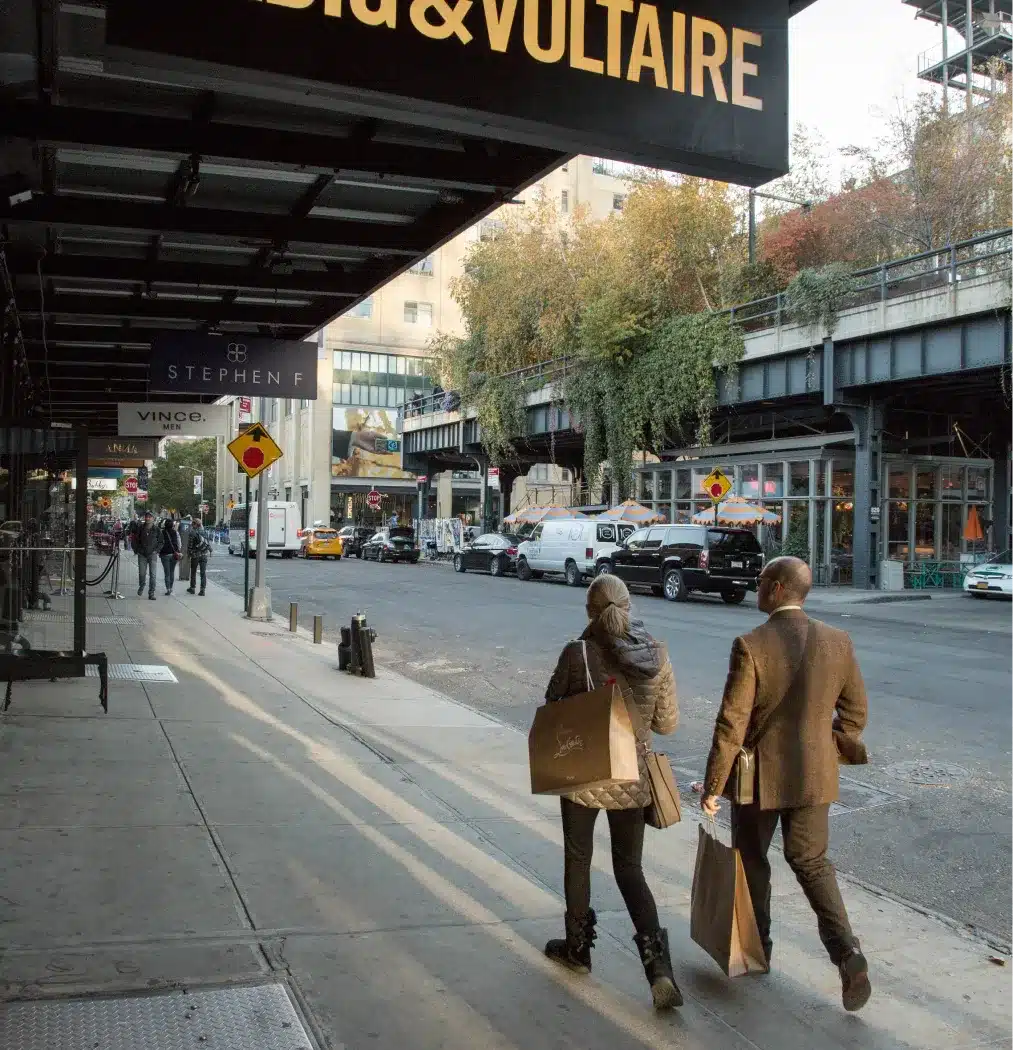 Couple carrying shopping bags through an urban district with greenery and elevated walkways