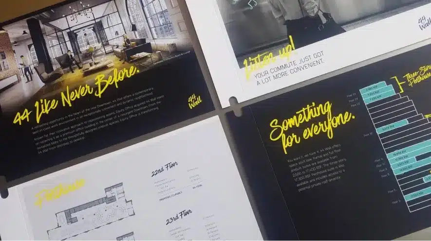 Close-up of 44 Wall marketing brochures with vibrant typography and architectural visuals