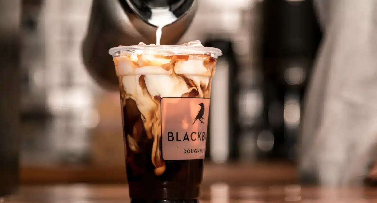 Close-up of an iced coffee with swirling cream from Blackbird Doughnuts café