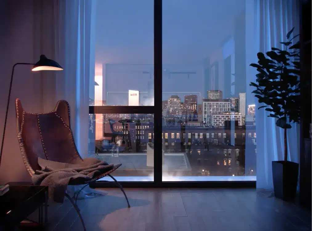 Upscale residential interior showcasing panoramic views of Boston’s skyline at twilight