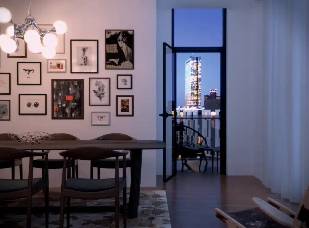 Stylish dining space in a modern high-rise with artistic wall decor and a city balcony view