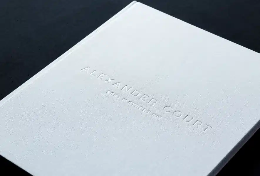 Minimalist white Alexander Court brochure with embossed lettering on a dark background