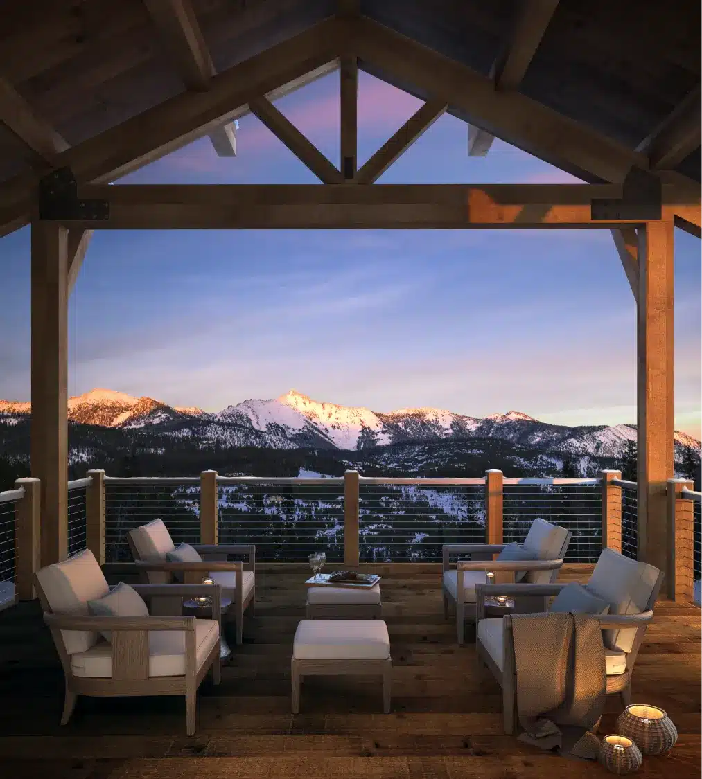 Scenic mountain view from a luxury wooden terrace at sunset with cozy seating arrangement