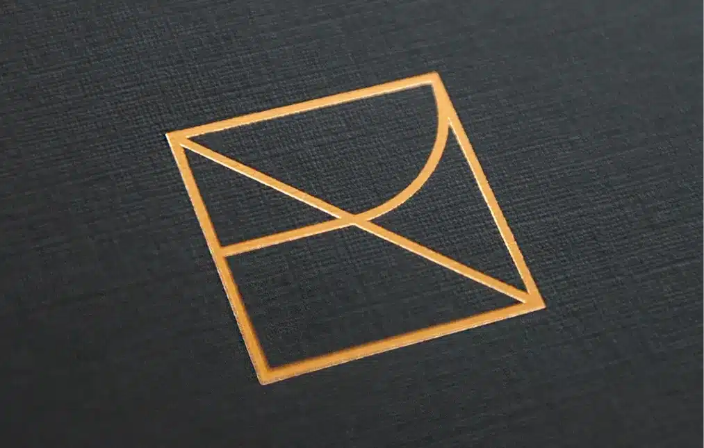 Elegant gold geometric logo on textured black paper representing a luxury brand identity