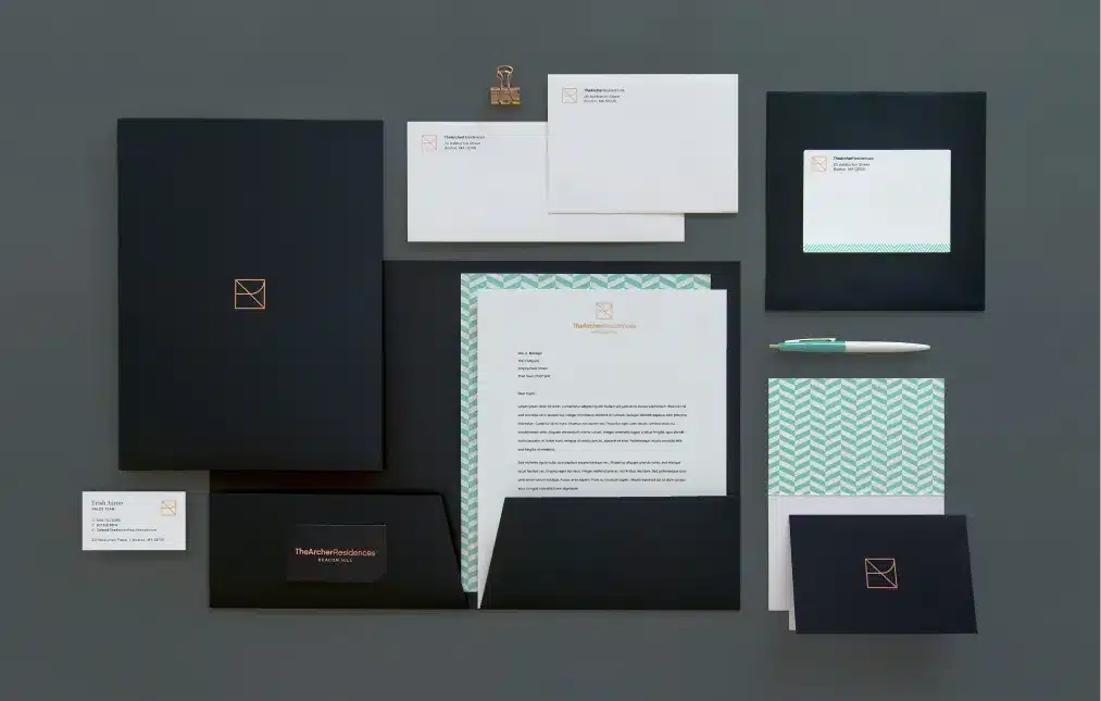 Branded office supplies including custom letterhead, folders, and envelopes with modern aesthetics