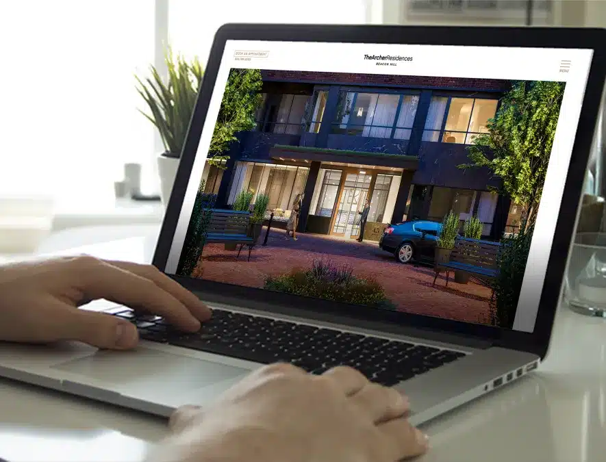 Laptop screen displaying a luxury apartment entrance on a real estate website