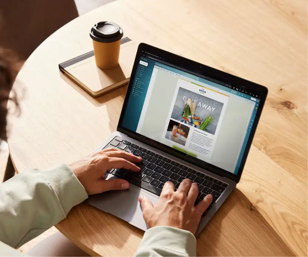 Hands on laptop keyboard editing promotional flyer for The Green event giveaway campaign