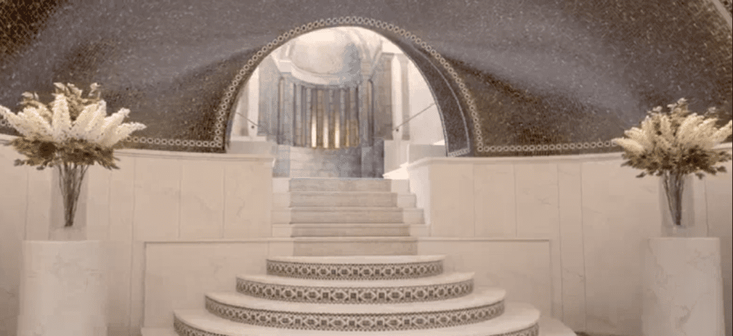 Luxurious staircase with decorative mosaic tiles leading into a grand architectural archway