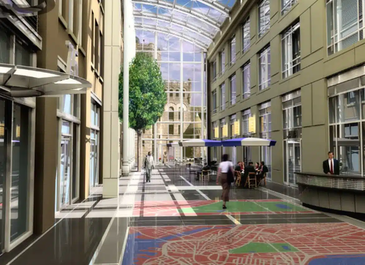 Interior courtyard featuring glass roof, patterned floors, and seating areas with umbrellas