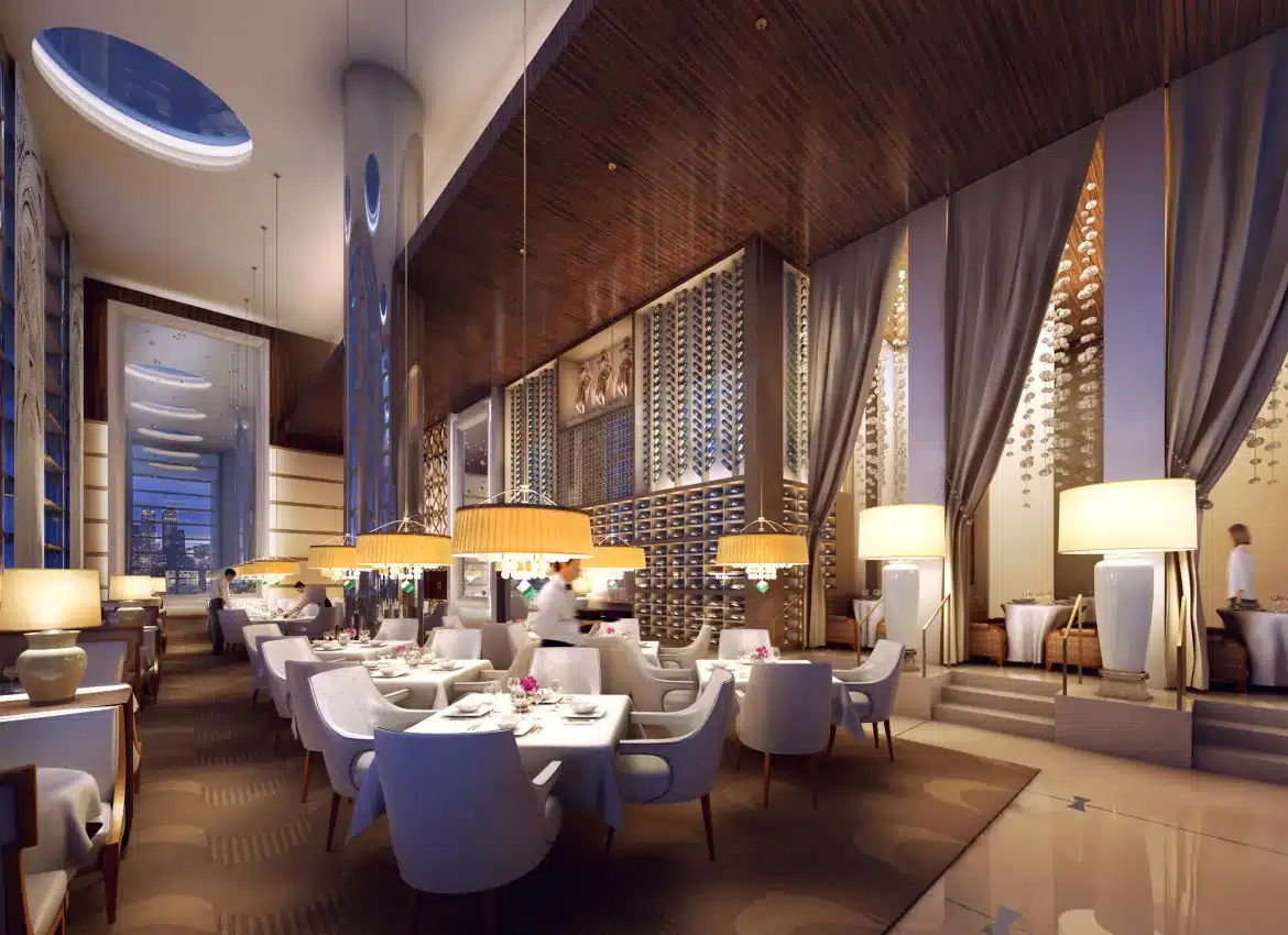 Elegant fine dining restaurant interior with high ceilings, chandeliers, and plush white seating