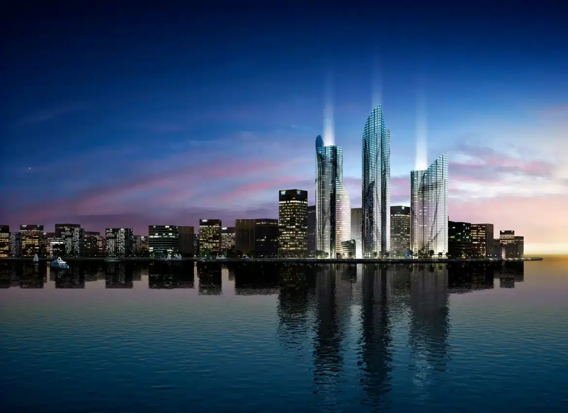 Futuristic illuminated skyscrapers reflecting on waterfront at dusk with surrounding city skyline