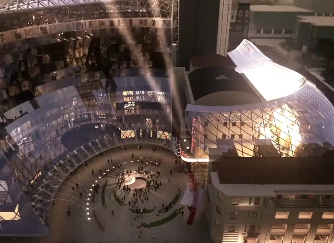 Night view of illuminated cultural complex with curved glass facade and lively outdoor gathering plaza