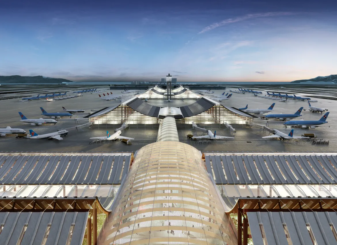 Expansive airport terminal with multiple aircrafts parked around curved glass buildings under twilight sky