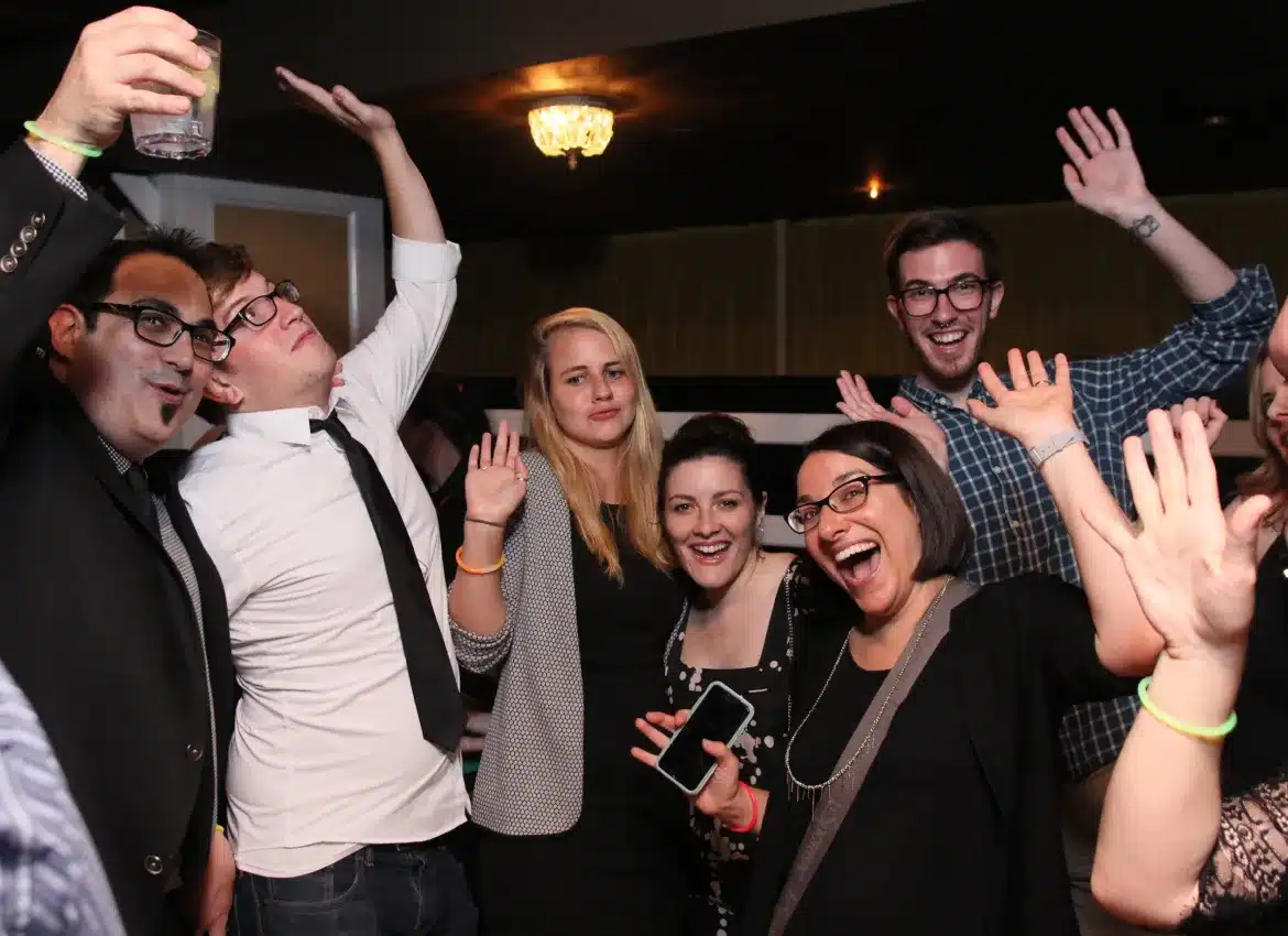 Group of collegues celebrating at party with cheerful poses and excited expressions