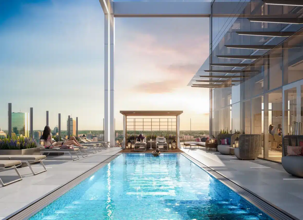 Rooftop infinity pool with skyline views surrounded by modern glass architecture at sunset