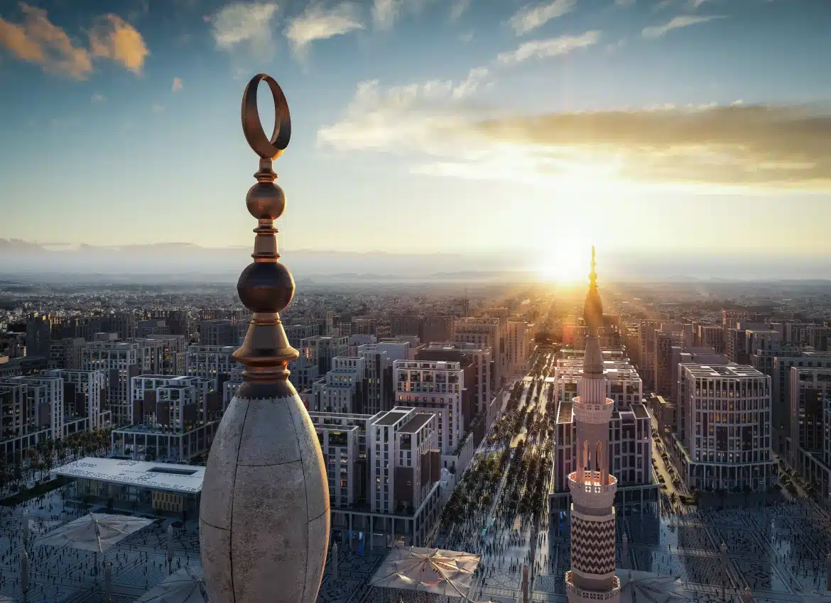 Cityscape view of Madinah with mosque minaret and crescent ornament at golden sunset