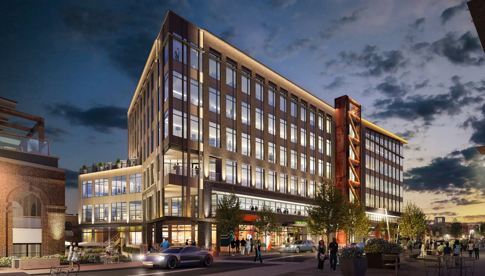 Multi-story commercial building with modern architecture, vibrant retail storefronts, and lively evening streetscape